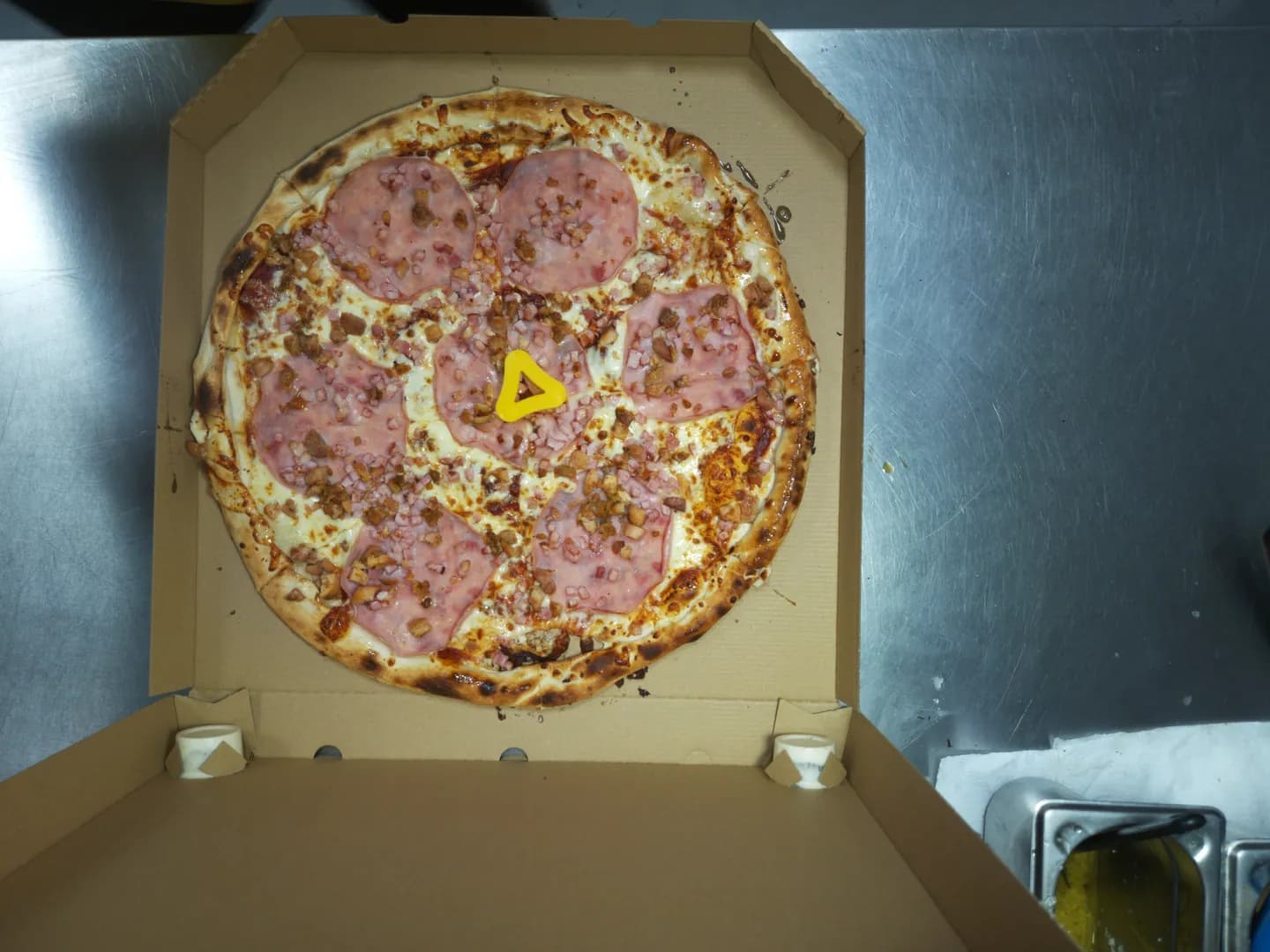 Live photo from the camera: a boxed pizza on the packing counter, seen from above